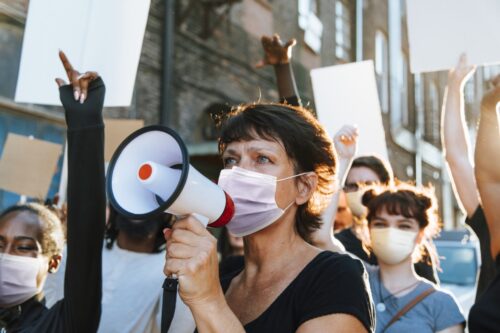 diverse people wearing mask protesting during covid  pandemic