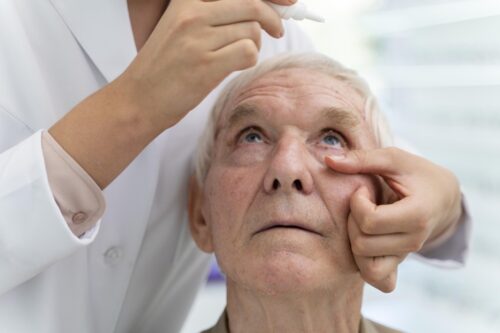 doctor pouring some eye drops for a patient