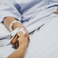 Daughter holding  her mothers hand in the hospital