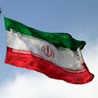 A big flag of Iran waving in the wind in Tehran, Iran.